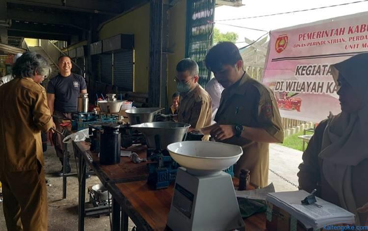 MENGECEK : DisperindagkopUKM saat mengecek timbangan di Pasar Kobar, belum lama ini. FOTO: IST